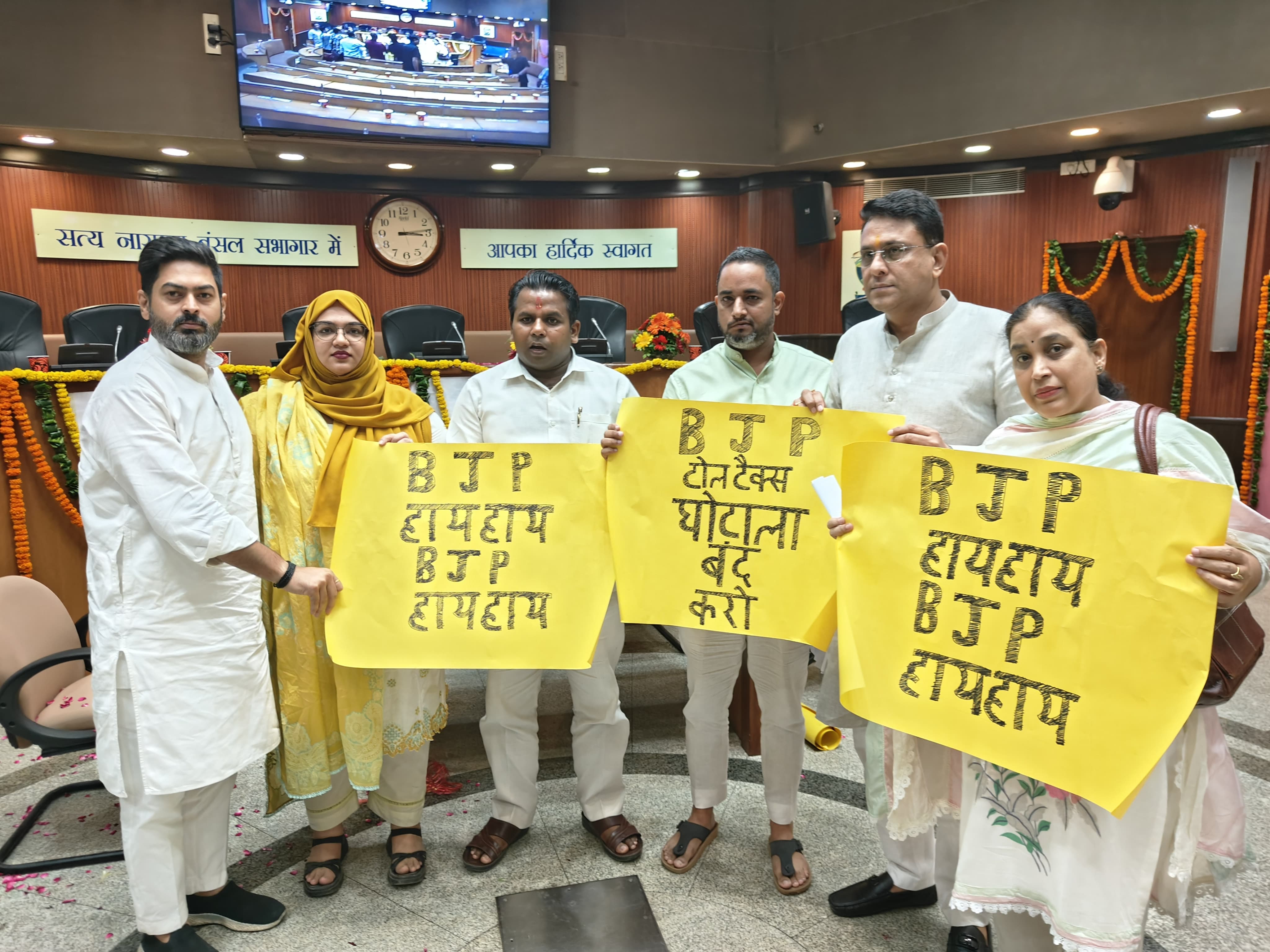 दिल्ली नगर निगम की स्टैंडिंग कमेटी बैठक में आप के सदस्य बैनर के साथ हंगामा करते हुए 
